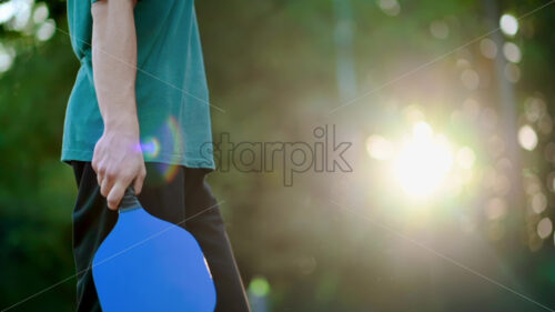 Man playing Pickleball, making ball pitch with a racket on an outdoor court. Slow motion - Starpik Stock