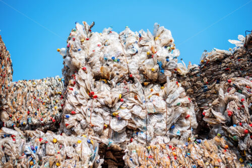 Multiple cubes of compressed plastic garbage near the waste recycling factory in open air - Starpik Stock