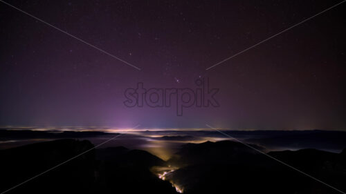 Night stars timelapse in the mountains with moving clouds. Ceahlau National Park, Romania - Starpik Stock