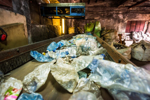Plastic garbage on a conveyor belt at waste recycling factory - Starpik Stock