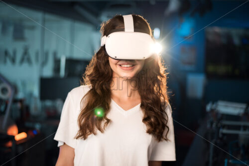 Portrait of a young smiling woman in VR glasses - Starpik Stock