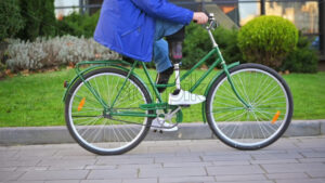 Slow motion view of a man with prosthetic legs. Riding a bike on the street with greenery - Starpik Stock