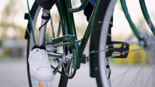 Slow motion view of a man with prosthetic legs. Sitting on his bike - Starpik Stock