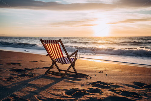 Two folding chairs sitting on a beach and in the distance an amazing view of an ocean whose waves come to the shore - Starpik Stock