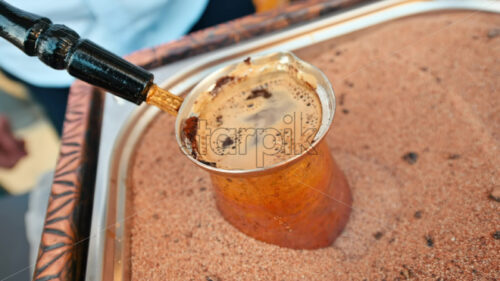 Video – Turkish coffee preparation on hot sand, adding sugar cubes - Starpik Stock