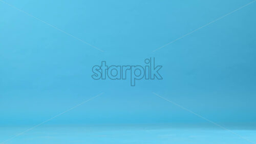 View of a man with prosthetic legs and white sneakers walking, blue background - Starpik Stock