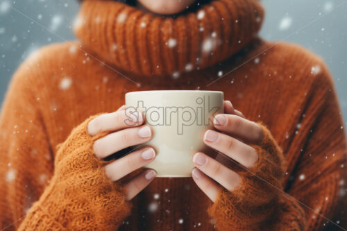 Woman in a warm sweater holding a mug winter, snowing, cold close up - Starpik