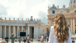 Woman with long hair enjoying Vatican Saint Peter Cathedral square city views in Rome Italy, slow motion - Starpik Stock
