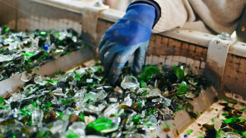 Worker hand sorting glass on a line, small pieces vibrating, slow motion - Starpik Stock