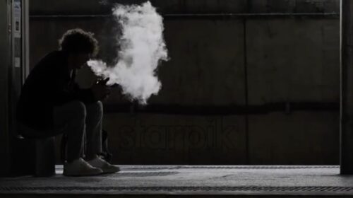 Cannes, France – Aprile 20, 2022: Man smoking electronic cigarettes with big smoke at train station - Starpik Stock