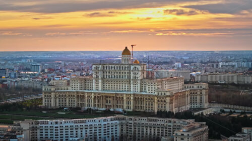 Aerial drone view of Palace of the Parliament in Bucharest downtown at sunset. Multiple districts around, Romania - Starpik Stock