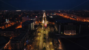 Aerial drone view of illuminated cityscape in the night. moving traffic on the road in Bucharest, Romania - Starpik Stock
