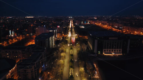 Aerial drone view of illuminated cityscape in the night. moving traffic on the road in Bucharest, Romania - Starpik Stock