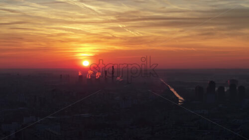 Aerial drone view of thermal power stations in Bucharest at sunset. Red sun. Romania - Starpik Stock