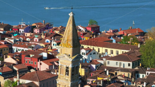 Video – Aerial drone view of the Church of Saint Martin Bishop surrounded by colourful houses in Burano Island, Italy - Starpik Stock