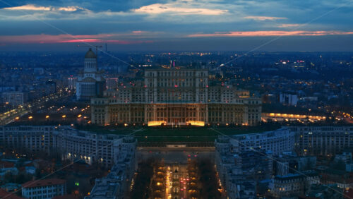 Video - Aerial hyperlpase timelapse drone view of illuminated Palace of the Parliament in Bucharest downtown in the evening. Multiple districts around. Romania