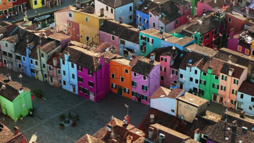 Video Aerial drone view of boats on the sides of a canal near the colourful houses of Burano, Italy - Starpik Stock