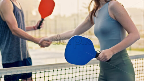 Video Man and woman doing a secret handshake after playing pickleball after rain - Starpik Stock