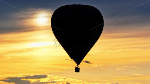 Video Aerial drone view of a hot air balloon flying above the clouds at sunset - Starpik Stock