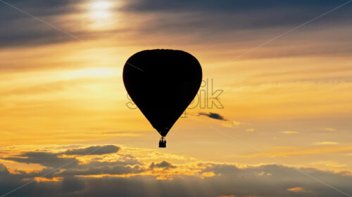 Video Aerial drone view of a hot air balloon flying above the clouds at sunset - Starpik Stock