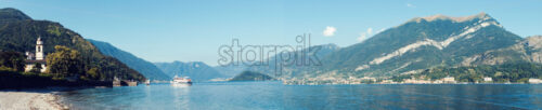 Panoramic shot of Lake Como with passenger ship cruising on water. - Starpik
