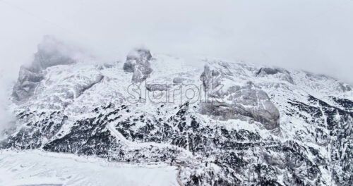 Aerial drone view of Portavescovo covered in snow, in Arabba, Italy - Starpik Stock