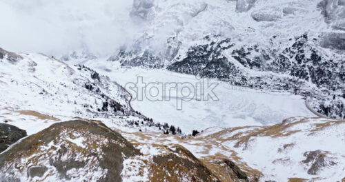 Aerial drone view of Portavescovo covered in snow, in Arabba, Italy - Starpik Stock