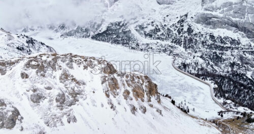 Aerial drone view of Portavescovo covered in snow, in Arabba, Italy - Starpik Stock