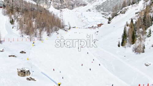 Aerial drone view of people skiing in Colfosco in South Tyrol, Dolomites, Northern Italy - Starpik Stock