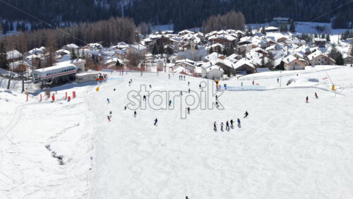 Aerial drone view of people skiing in Colfosco in South Tyrol, Dolomites, Northern Italy - Starpik Stock