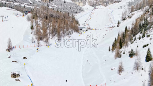 Aerial drone view of people skiing in Colfosco in South Tyrol, Dolomites, Northern Italy - Starpik Stock