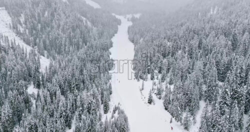 Aerial drone view of people skiing on the mountains in the Corvara village in South Tyrol, Dolomites, in northern Italy - Starpik Stock