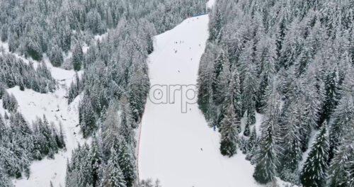 Aerial drone view of people skiing on the mountains in the Corvara village in South Tyrol, Dolomites, in northern Italy - Starpik Stock