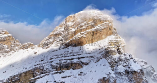 Aerial drone view of snow on the Sassongher mountain in the Dolomites, Italy with the blue sky on the background - Starpik Stock