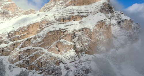 Aerial drone view of snow on the Sassongher mountain in the Dolomites, Italy with the blue sky on the background - Starpik Stock