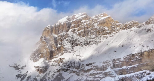 Aerial drone view of snow on the Sassongher mountain in the Dolomites, Italy with the blue sky on the background - Starpik Stock