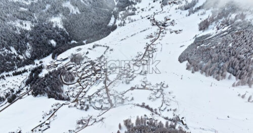 Aerial drone view of the Colfosco mountain village covered in snow, in South Tyrol, Dolomites, Northern Italy - Starpik Stock