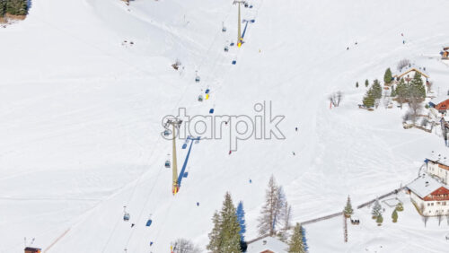 Aerial drone view of the Colfosco mountain village covered in snow, in South Tyrol, Dolomites, Northern Italy - Starpik Stock