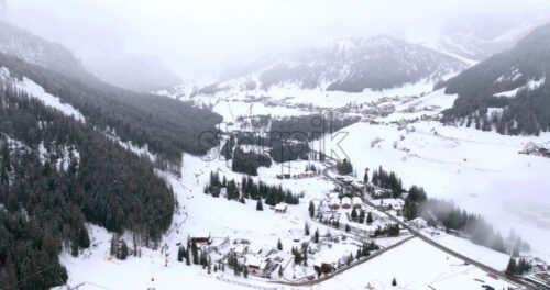 Aerial drone view of the Corvara village covered in snow, in South Tyrol, Dolomites, in northern Italy - Starpik Stock