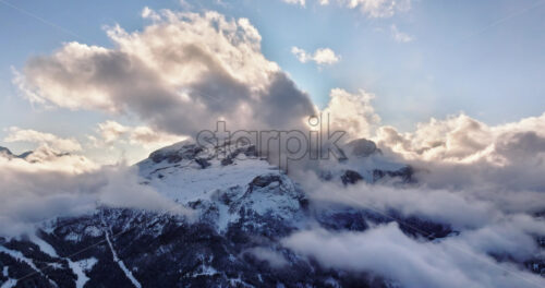 Aerial drone view of the Gardena Pass high mountain pass in the clouds, in the Dolomites, Italy - Starpik Stock