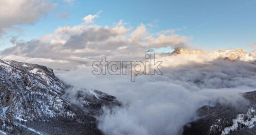 Aerial drone view of the Gardena Pass high mountain pass in the clouds, in the Dolomites, Italy - Starpik Stock