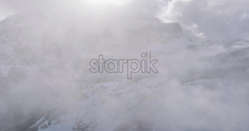 Aerial drone view of the Gardena Pass high mountain pass in the clouds, in the Dolomites, Italy - Starpik Stock