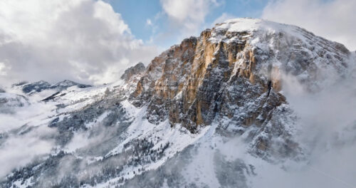 Aerial drone view of the Gardena Pass high mountain pass in the clouds, in the Dolomites, Italy - Starpik Stock