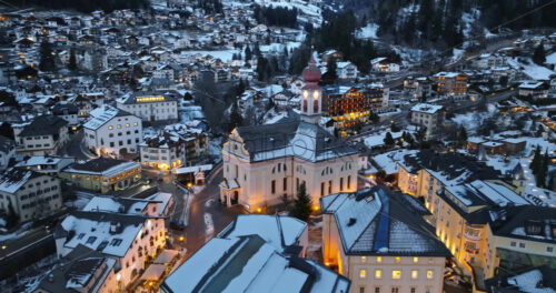 Aerial drone view of the Ortisei town covered in snow, within the Dolomites, in northern Italy - Starpik Stock