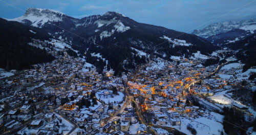Aerial drone view of the Ortisei town covered in snow, within the Dolomites, in northern Italy - Starpik Stock