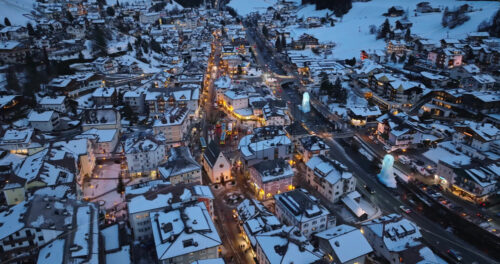 Aerial drone view of the Ortisei town covered in snow, within the Dolomites, in northern Italy - Starpik Stock