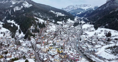 Aerial drone view of the Ortisei town covered in snow, within the Dolomites, in northern Italy - Starpik Stock