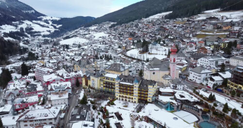 Aerial drone view of the Ortisei town covered in snow, within the Dolomites, in northern Italy - Starpik Stock