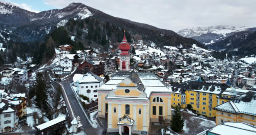 Aerial drone view of the Ortisei town covered in snow, within the Dolomites, in northern Italy - Starpik Stock