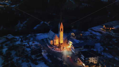 Aerial drone view of the San Lorenzo Church illuminated at night in the Selva di Cadore comune in Dolomites, Italy - Starpik Stock